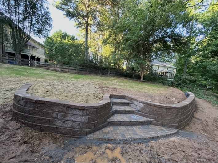 Curved retaining wall and paver steps creating a level backyard area
